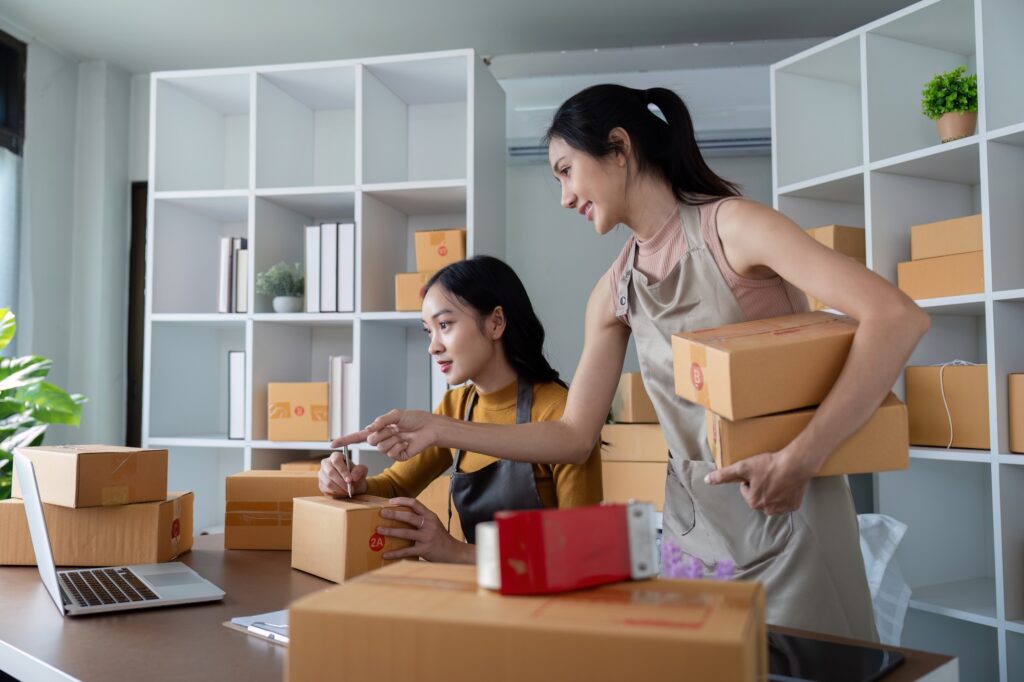 Asian women organizing ecommerce logistics for online business. Concept of teamwork, efficient