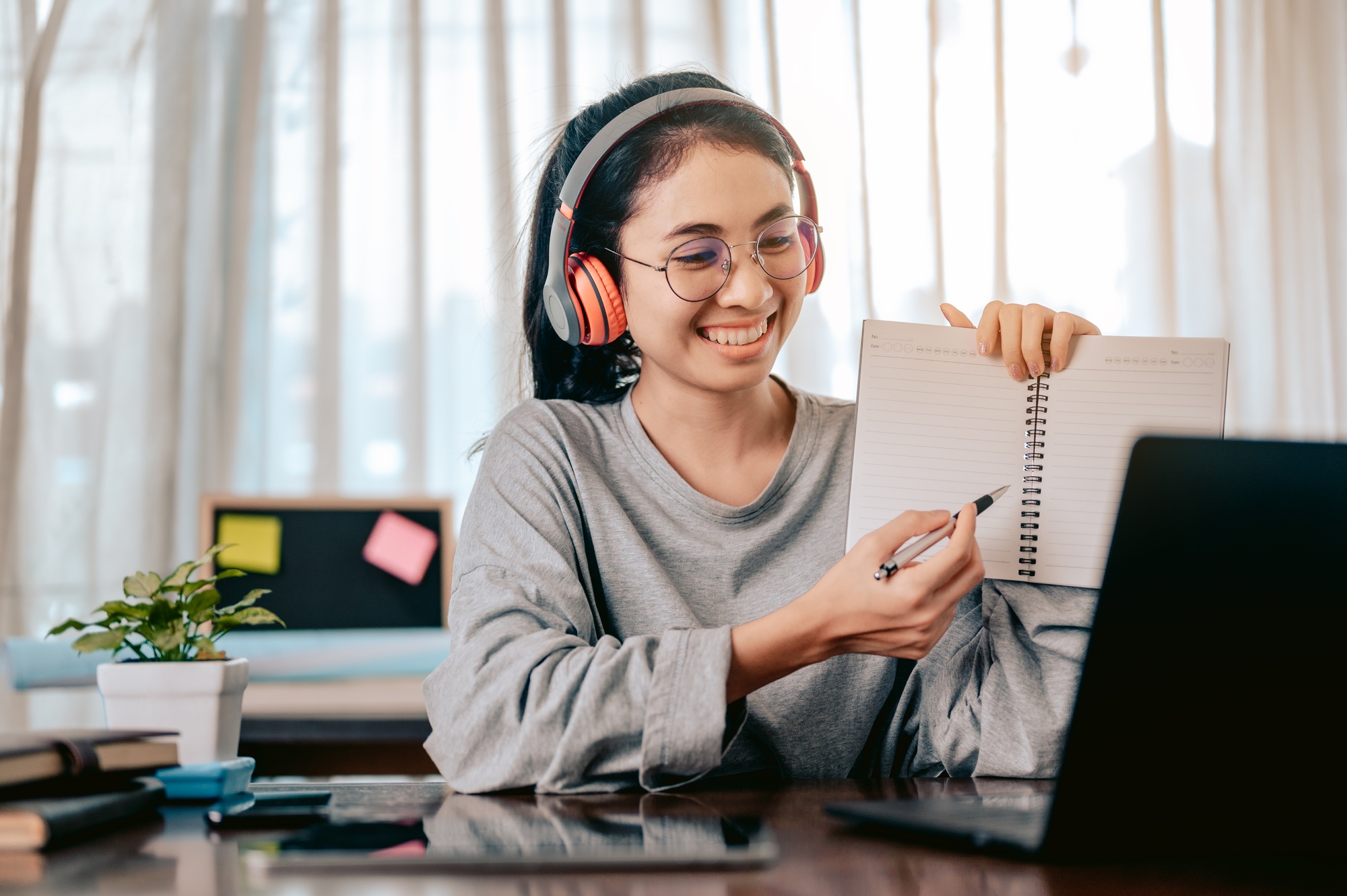 Businesswomen is using notebook computers and wear headphones for online meetings and working from.