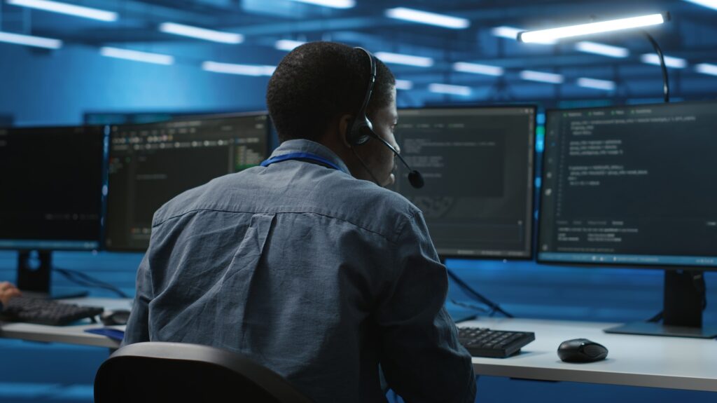 IT support expert in server room talking on headphones with admin